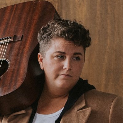 Kellie Loder shoulders their guitar